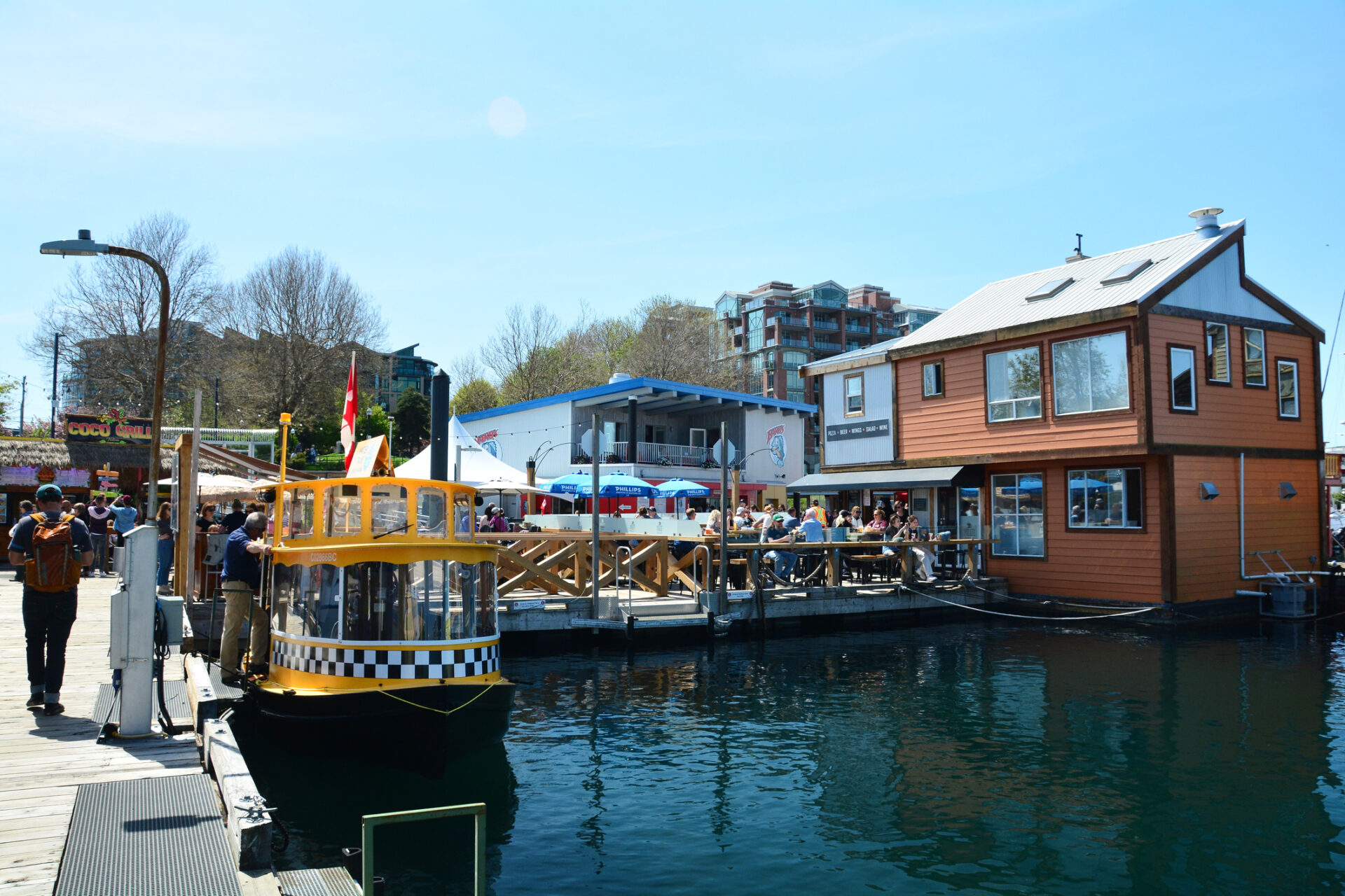 The sights at Fisherman's Wharf in Victoria BC. People on vacation sightseeing and eating at restaurants.