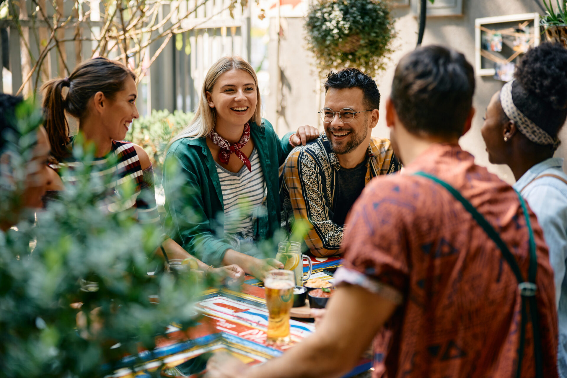 Group of happy friends talking and having fun in a pub's outdoor patio